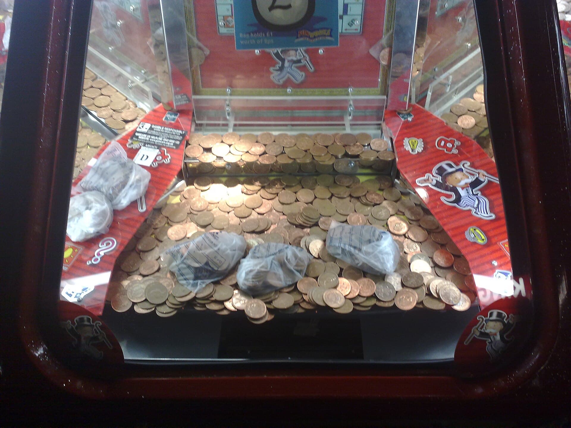 Copper coins piled on the shelf of a seaside coin pusher