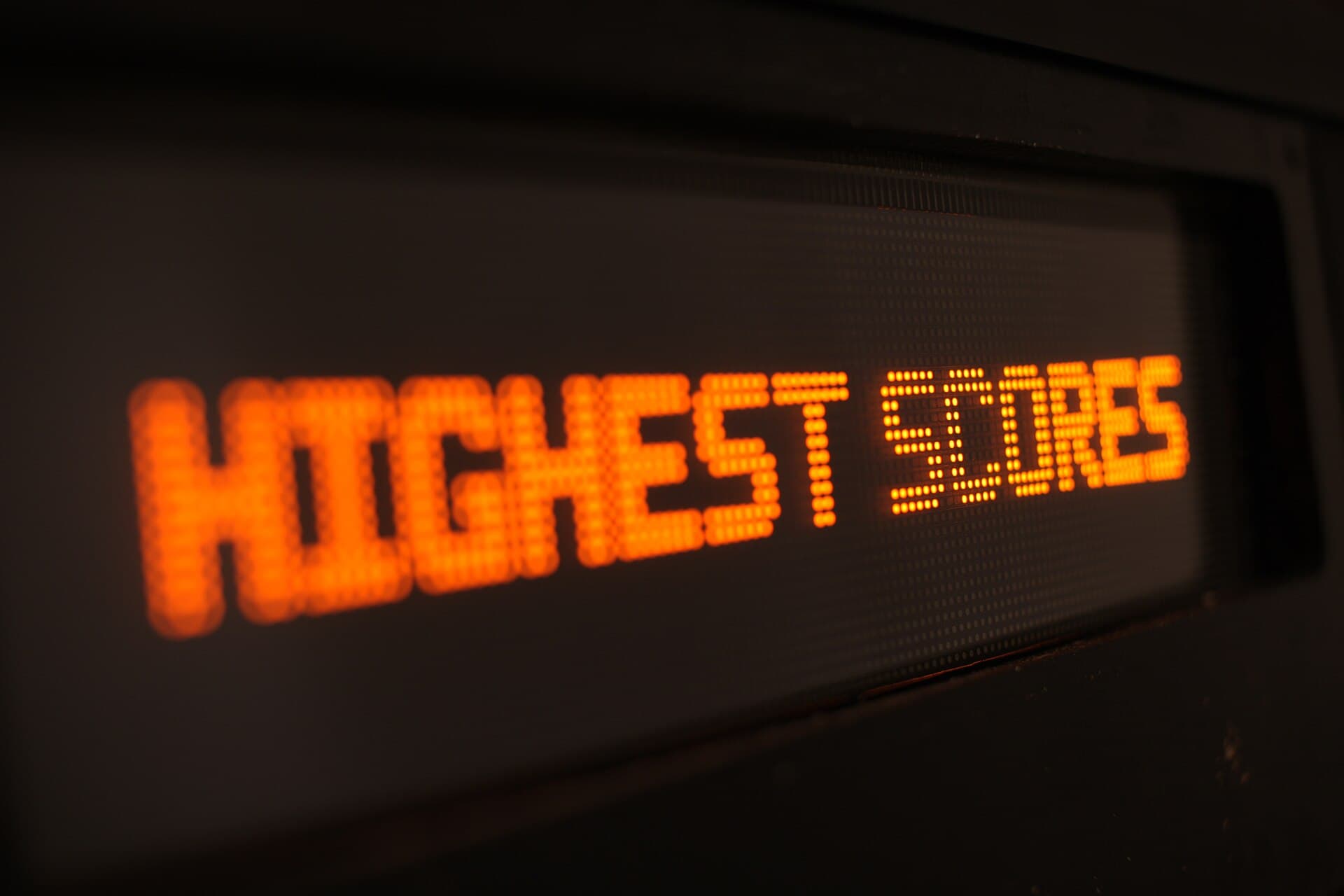 An orange dot-matrix pinball display reading Highest Scores